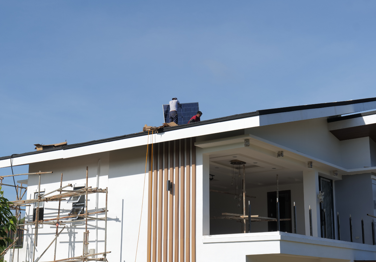 Solar panels being installed on the roof of a modern two-storey home